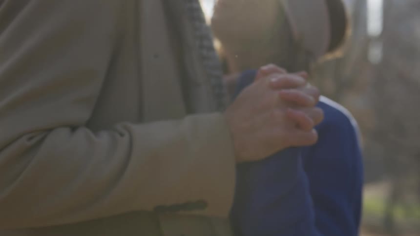 A man and woman holding hands outside