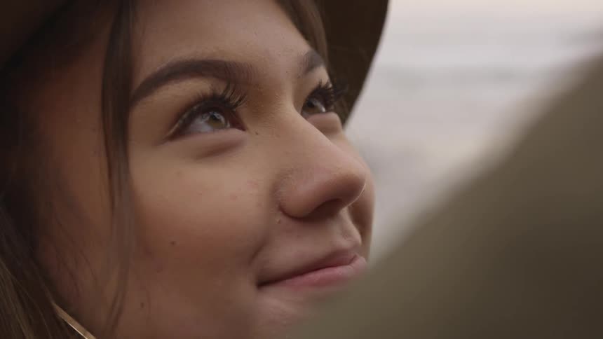A woman looks up at another person smiling