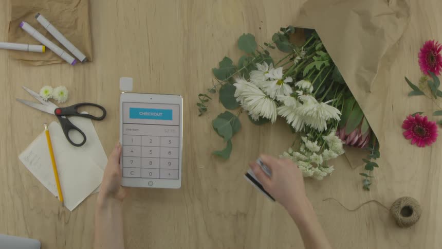 A person swiping a credit card at a tablet