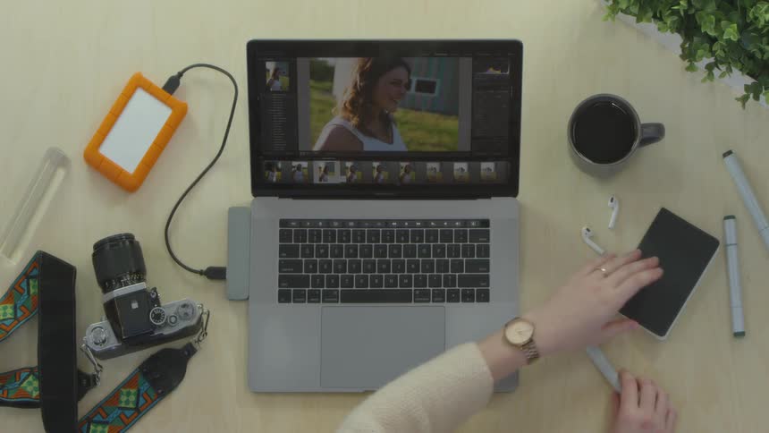 A person using a laptop and a notebook