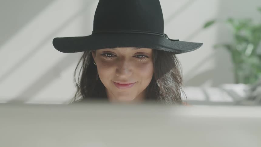 A woman sitting at a computer and looking at the screen
