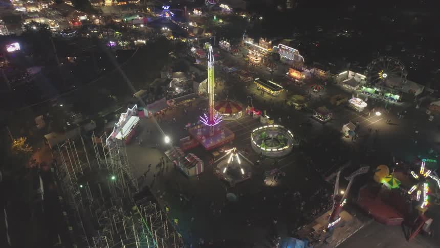 A carnival that is in a parking lot at night