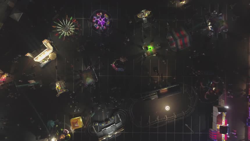 A carnival is set up in a parking lot at night