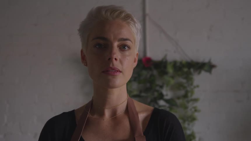 Woman with short hair turns and looks into the camera