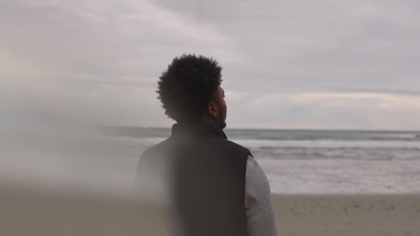 A man looking into the distance at the beach