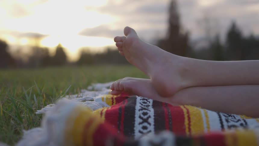 A woman laying on a blanket outdoors