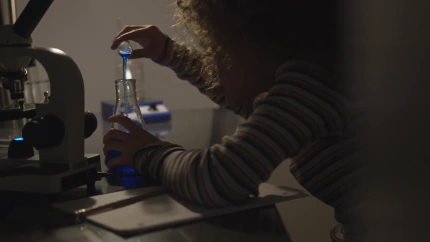 A child mixing chemicals in a laboratory