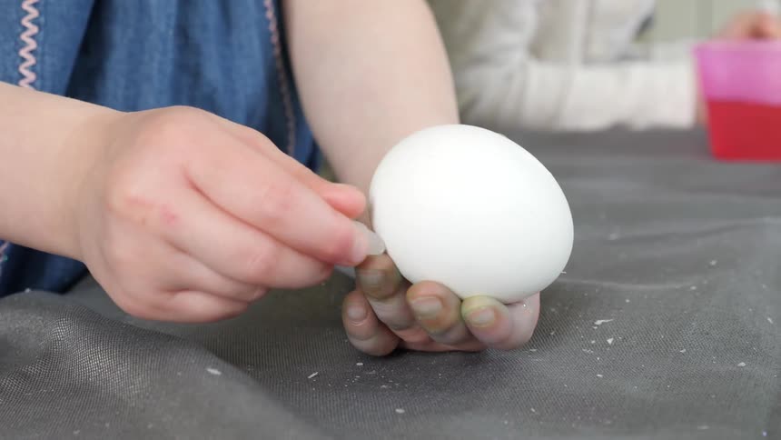 Child rubbing clear wax on an egg