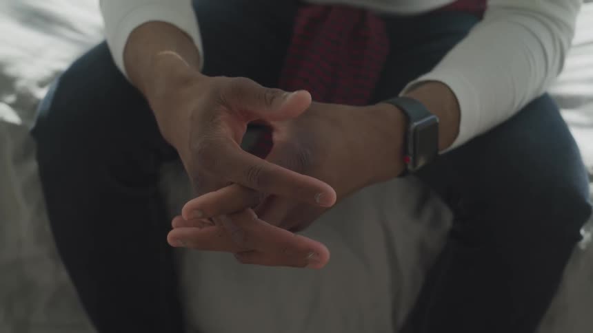 A man sitting and rubbing his hands together
