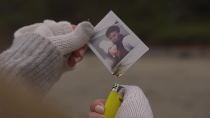 Woman lighting a photo on fire with a yellow lighter