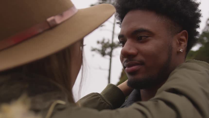 A man and woman hug and gaze into each other's eyes
