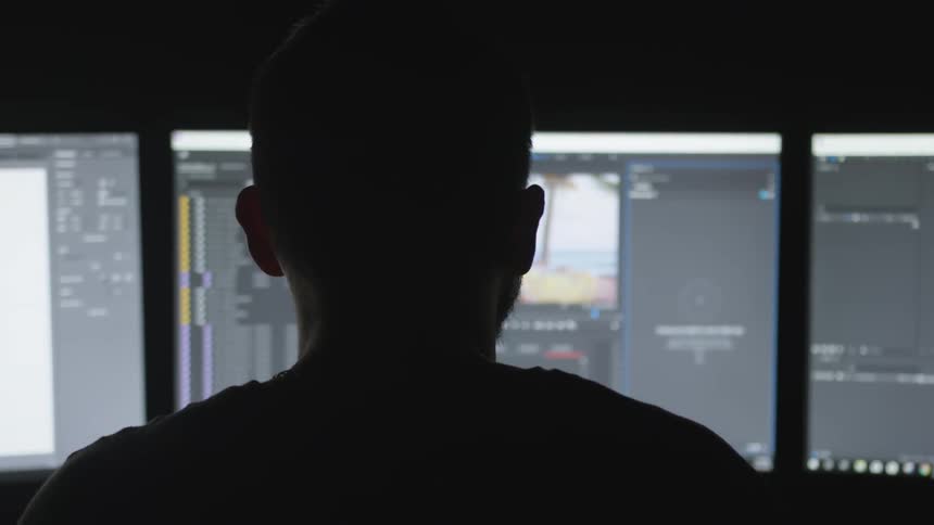 A person with multiple computer monitors in front of them