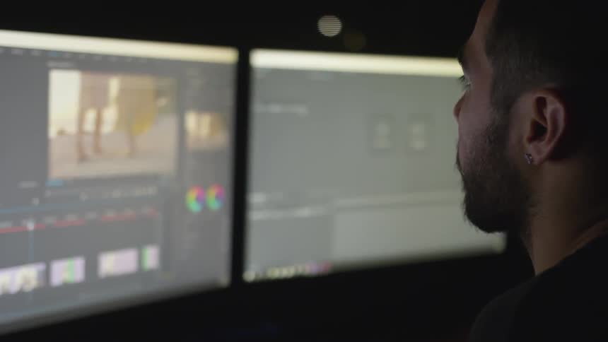 A man looks at a screen while editing a video