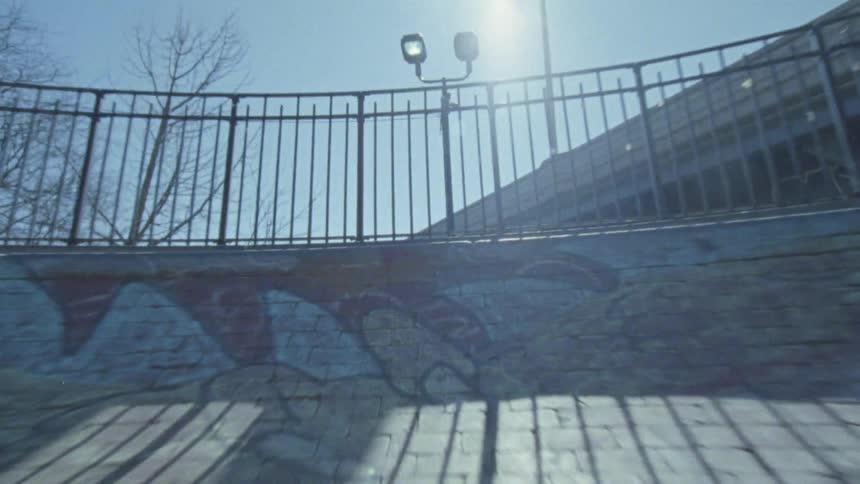 A skate skates up a ramp in the skate park