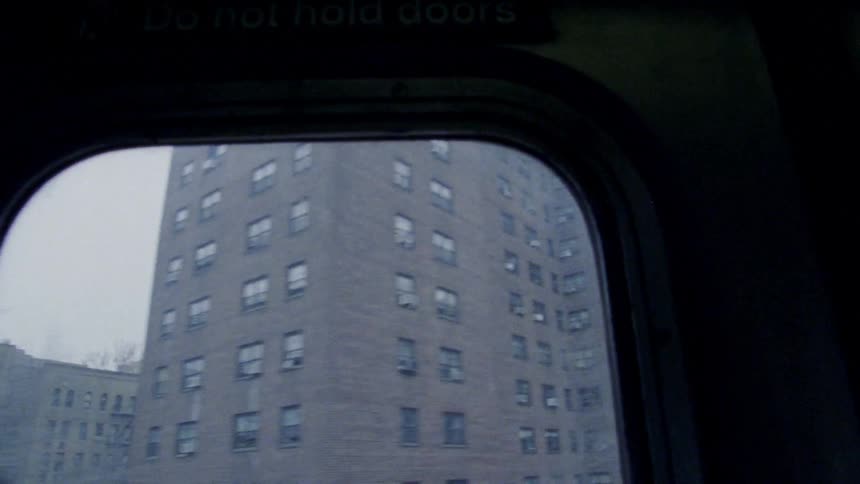 Buildings are viewed out of the window of a moving vehicle