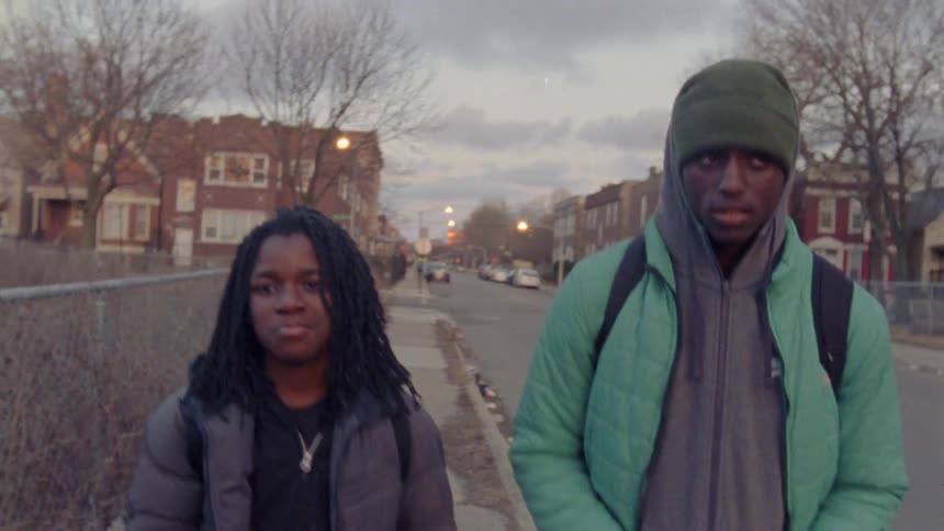 Black couple walking by empty lot on a cloudy day