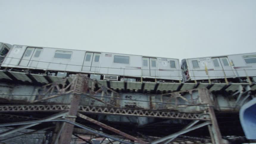 Subway moving over a graffiti and rust lined track