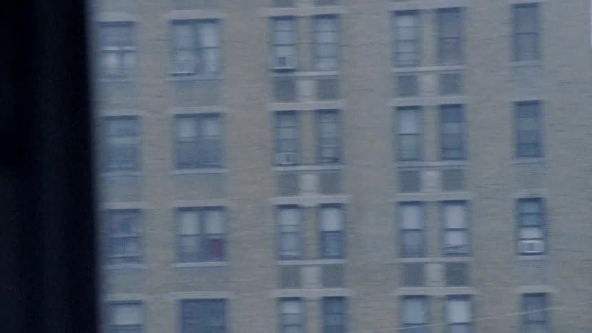 The train moves past the buildings in the city