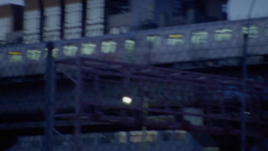 A train travels in a city at dusk