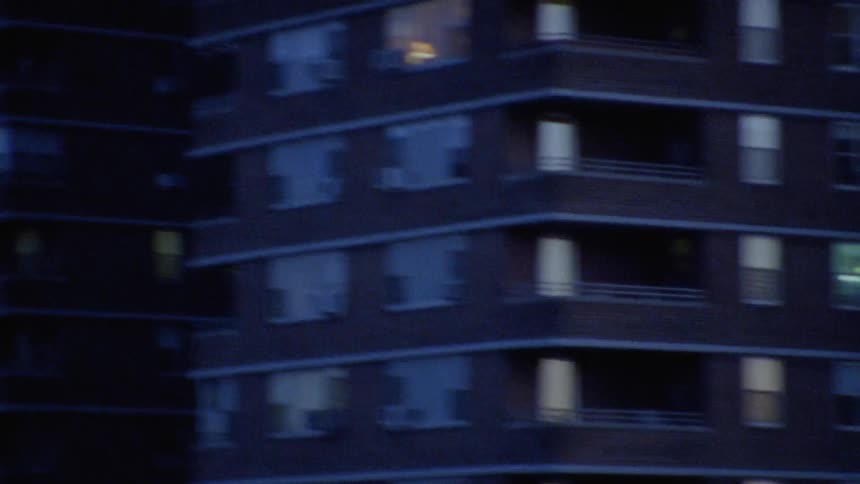 A car travels in a city at dusk