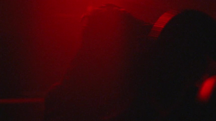 Two people box under red and purple flashing lights