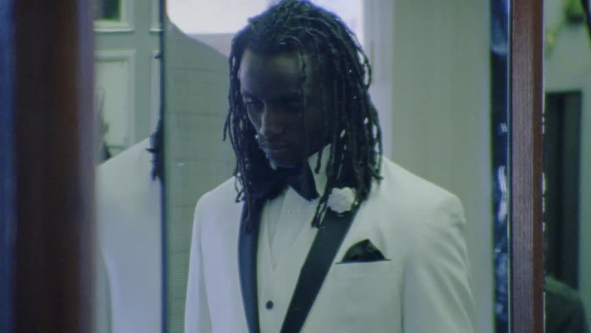 Man in white suit visible in mirror