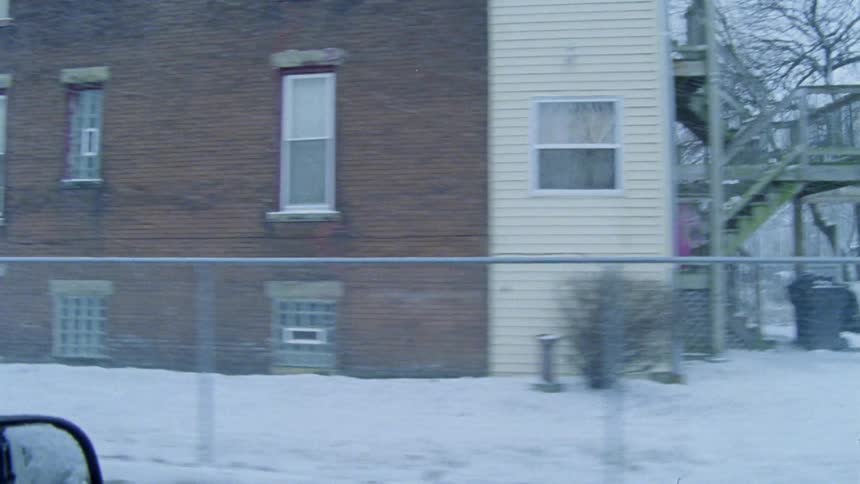 Driving down an older residential city road looking at houses and apartment buildings