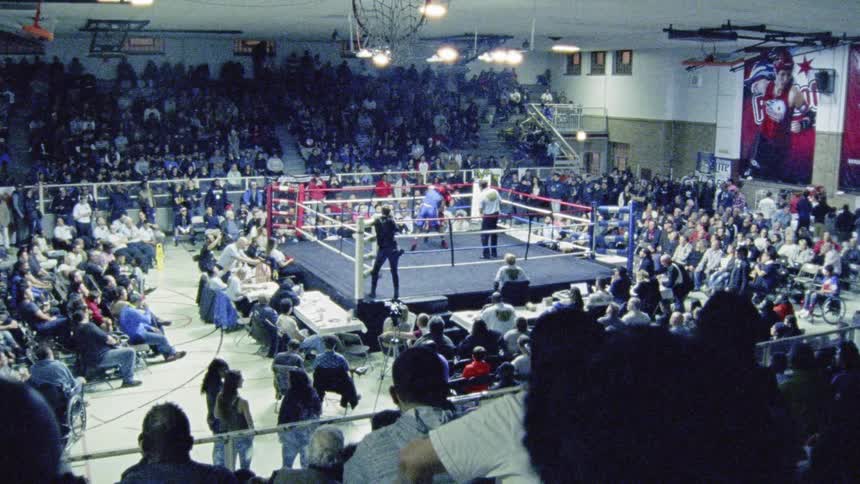 A boxing match on a crowded gymnasium
