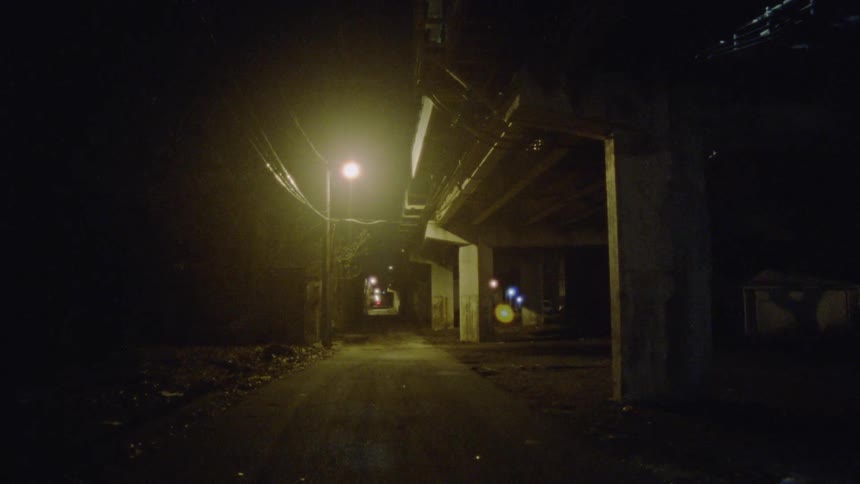 A street lamp shines on a city sidewalk at night