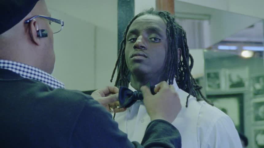 A man tying a bow tie on another man