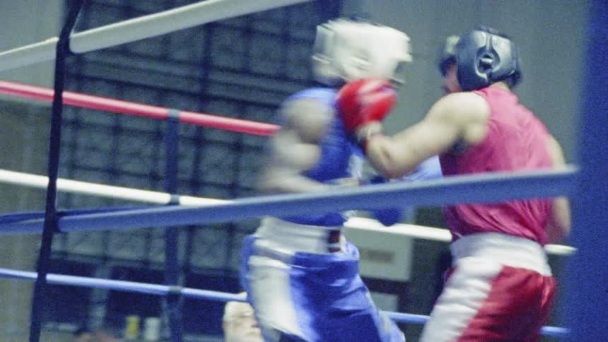 Two boxers fight in a boxing ring