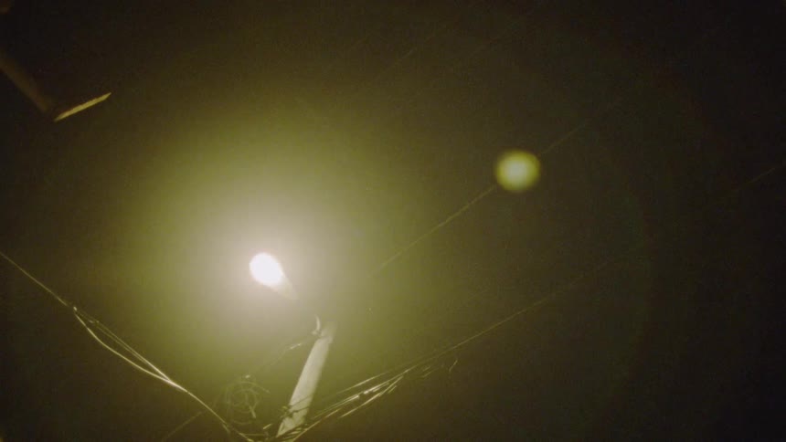 Power lines are lit up by a street lamp