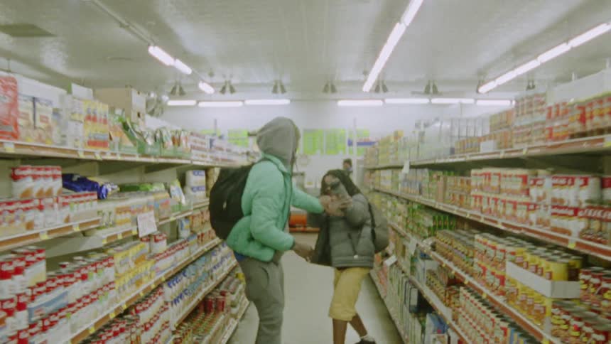 Two people play fighting in a grocery store