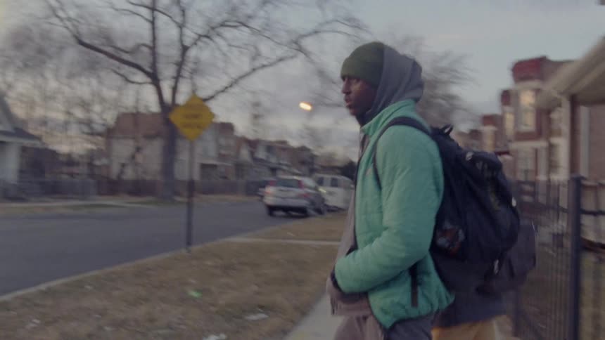Two people are walking in a suburban area