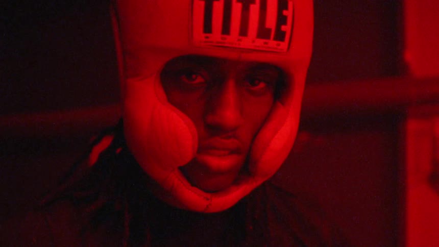 Red lights flash over a boxer