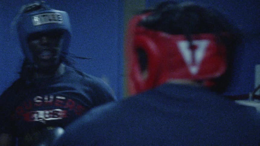 Two young men are fighting out a boxing match under flashing lights
