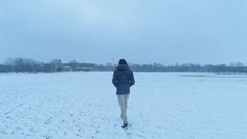 Person walks across a large field of snow