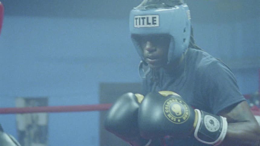 Boxers in a ring slap gloves before sparring then lights flash