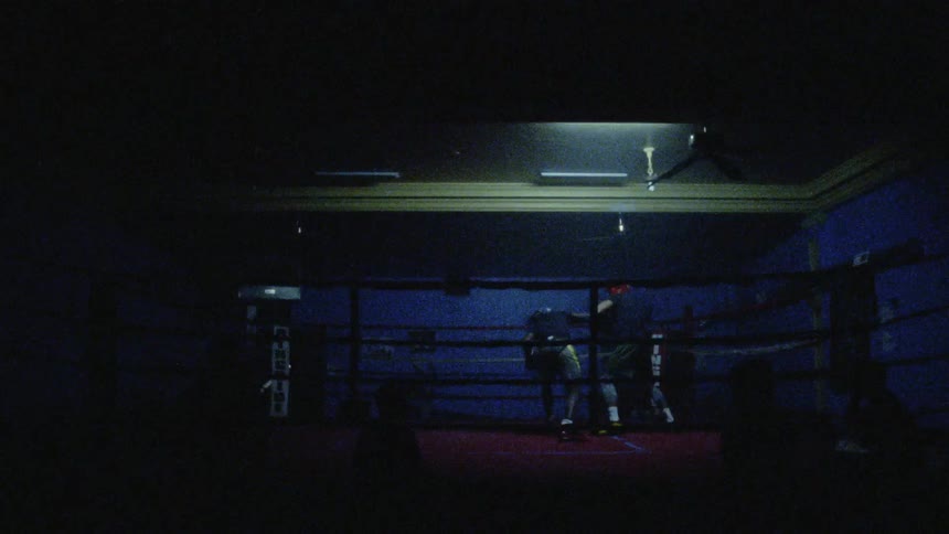 The lights are flashing fast during the boxing match in the ring