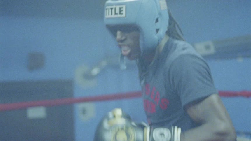 Two boxers flash in a dark ring with flashing lights