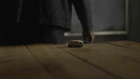 Man picks up chalk from a table and turns to a blackboard