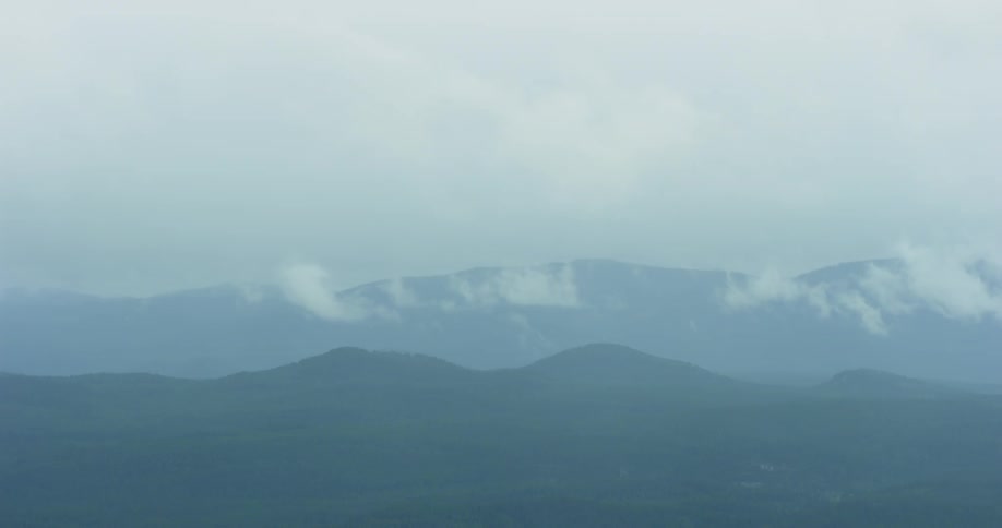 The clouds and fog cover the mountains in the distance
