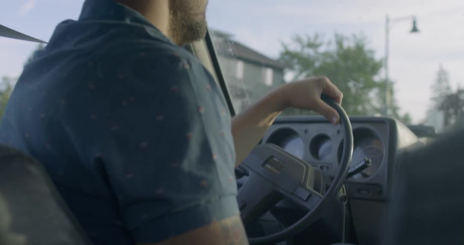 A man drives a car in a neighborhood