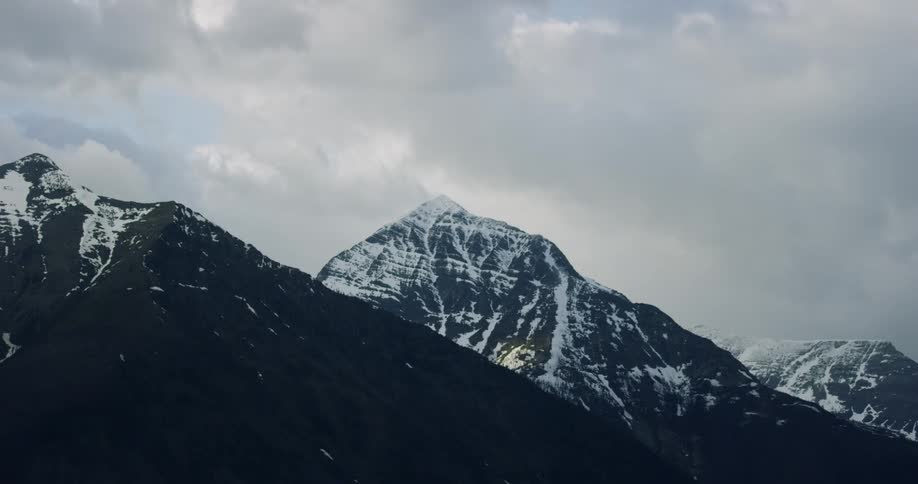 Snow covered mountains under a cloudy sky