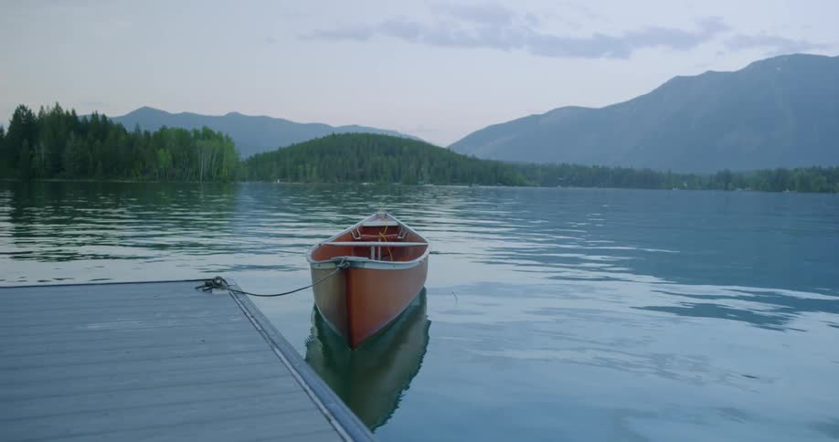 Canoe floats in the water as it is tethered to the dock