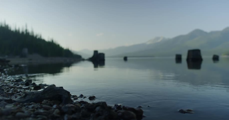 Rocks by the shore make ripples in the water