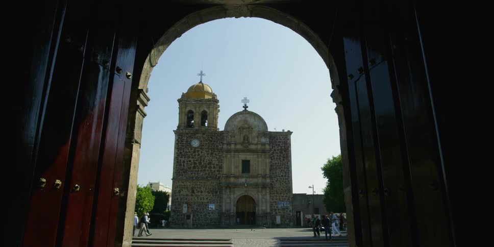 Archway frames a church (Parroquia Santiago Apostol)