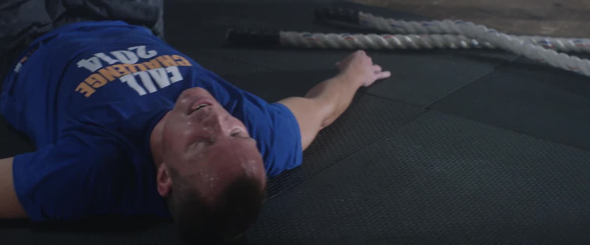 Man lying on his back in a gym