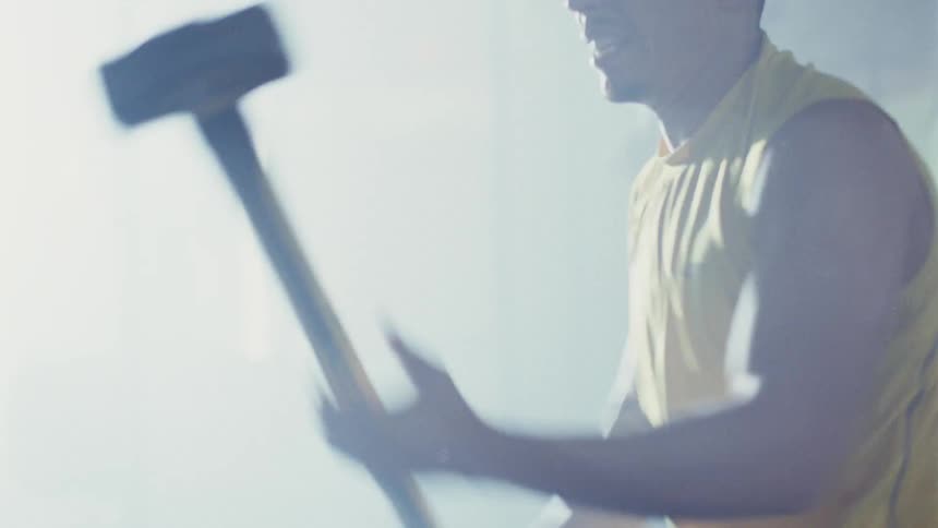 A person using a sledge hammer
