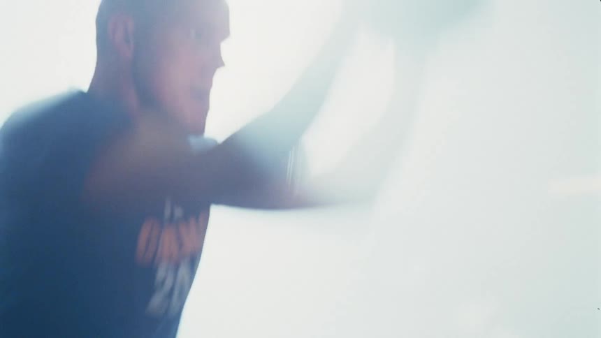 A man lifting a weighted ball at the gym